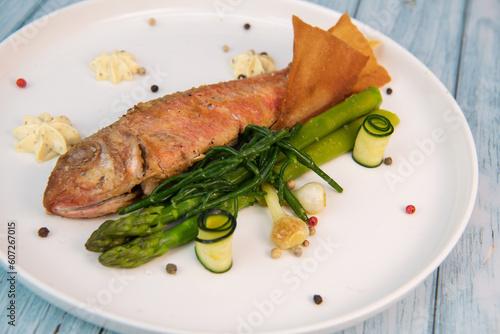 Fototapeta Naklejka Na Ścianę i Meble -  Plate of fried small fish red mullet with green asparagus. High quality photo