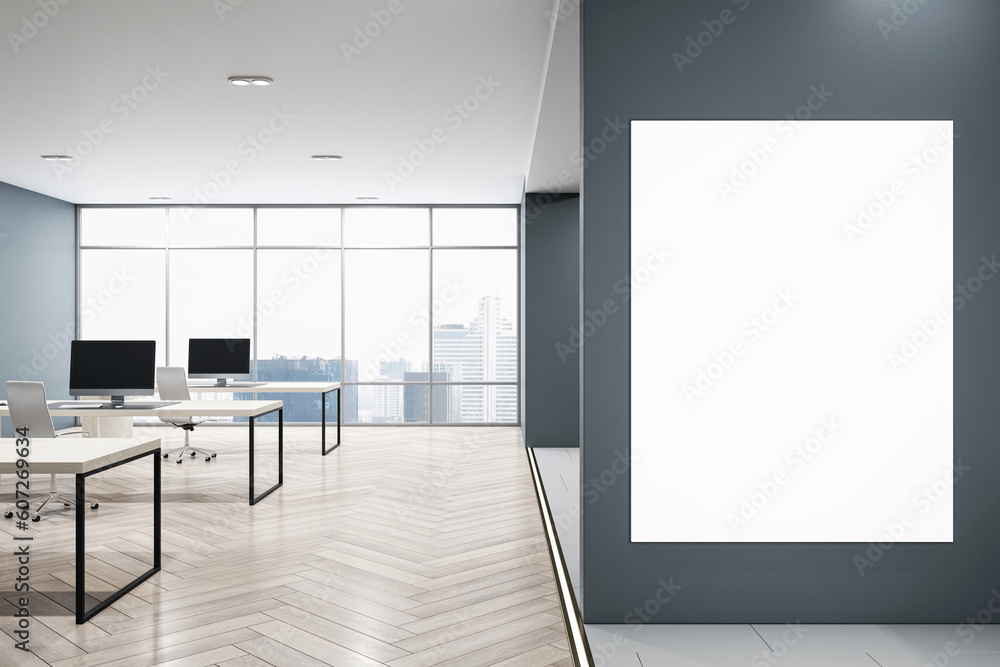 Fototapeta premium Front view on blank white poster on dark grey wall with space for your logo advertising in modern open space office with table and chairs on wooden floor. 3D rendering, mockup