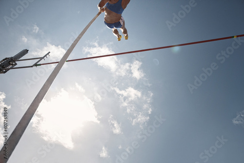 Pole vaulter clearing bar photo