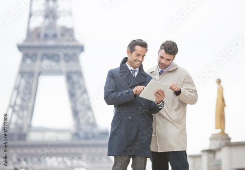 Canvas Print Businessmen using digital tablet near Eiffel Tower, Paris, France
