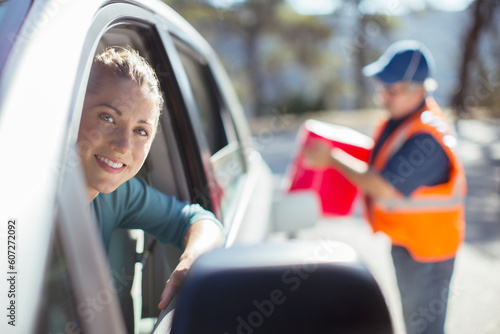 Roadside mechanic filling gas tank for woman photo