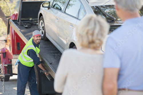 Photos Senior couple watching roadside mechanic prepare to tow car