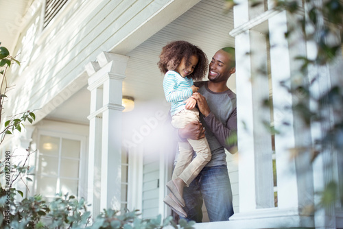 Happy father carrying daughter on porch