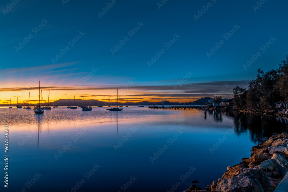 Beautiful sunrise with high cloud and boats on the water