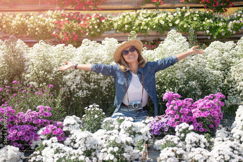 Fototapeta premium Beautiful woman enjoying flowers field, nice female lying down in meadow of flowers, pretty girl relaxing outdoor, having fun, happy young lady and spring green nature, Freedom concept.