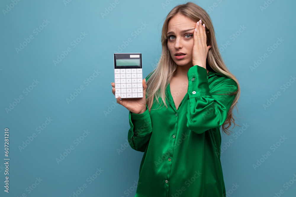 distressed blonde girl holding a calculator on a blue background distressed blonde girl holding a calculator on a blue background