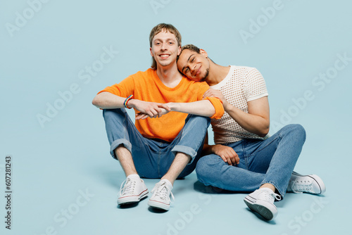 Full body fun young couple two gay men wear casual clothes together hugging cuddle look camera isolated on pastel plain blue color background studio portrait. Pride day june month love LGBTQ concept.