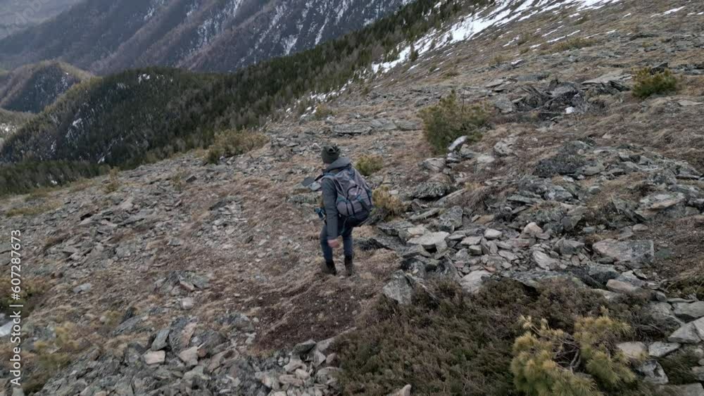 Man Hiking with backpack during the ascent of the peak in the summer. Concept trekking trips and active life with nature Man Hiking with backpack during the ascent of the peak in the summer. Concept trekking trips and active life with nature