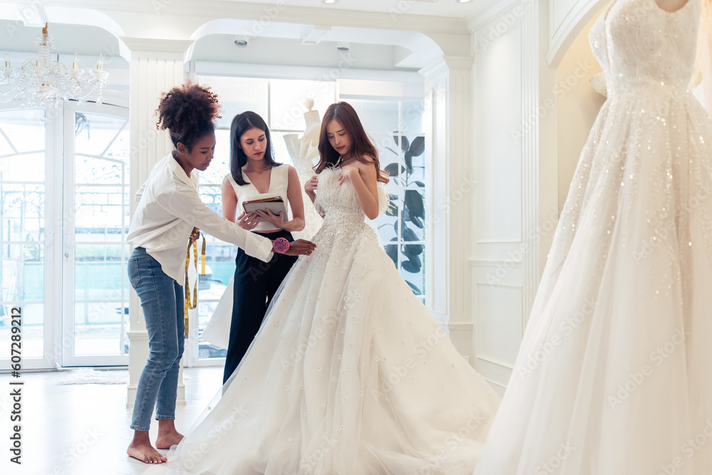Beautiful bride discussing details with the wedding planner in studio. Beautiful bride discussing details with the wedding planner in studio.