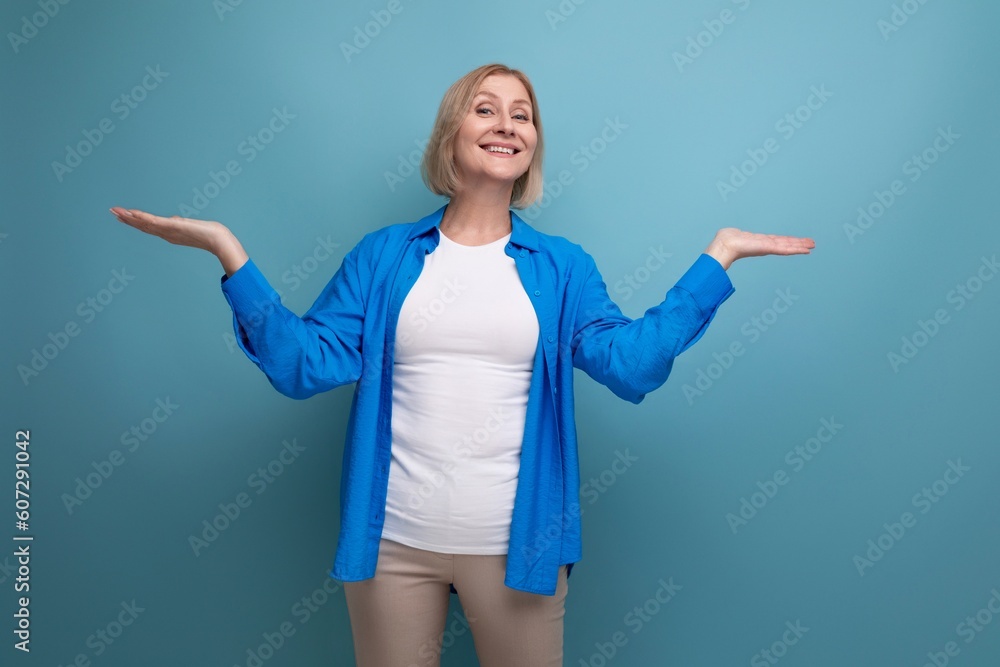 portrait of cheerful blonde 60s woman in casual stylish shirt with crossed arms on studio background portrait of cheerful blonde 60s woman in casual stylish shirt with crossed arms on studio background