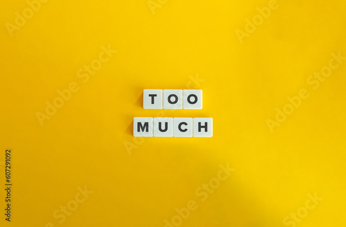 Too Much Word on Block Letter Tiles on Yellow Background. Minimal Aesthetic.