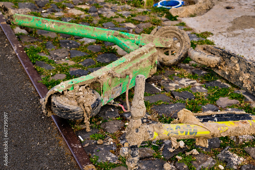 Obraz na płótnie Rental electric scooters covered in mud and garbage on embankment. w salonie