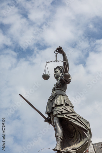 lady justice in Frankfurt with sword and cloudy sky as symbol for justice