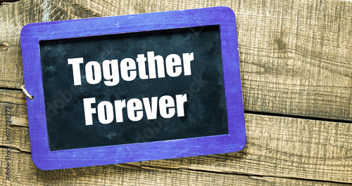 Together forever words on chalk board and wooden table.