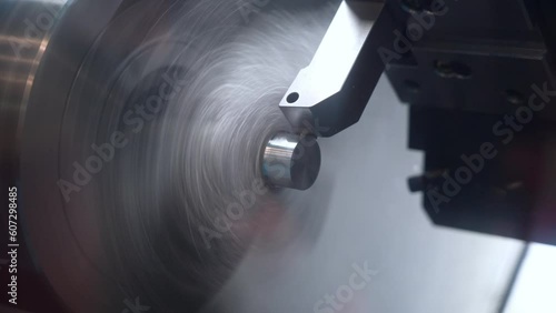 Precision machining and turning of a steel rod on a CNC lathe, a modern lathe for metal processing. photo