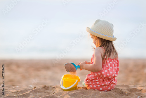 baby girl is sitting on beach and playing in sand in summer. holidays with children © Natalia