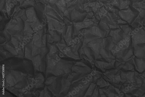 Black wrinkled paper texture. Grunge dark background