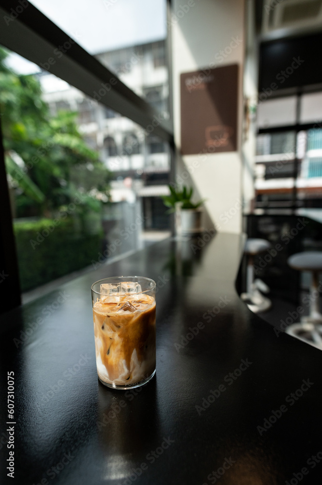 Iced coffee in a glass on the table. Selective focus.