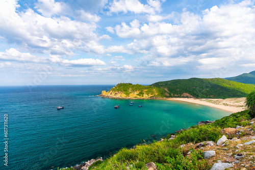 Beautiful bay on a sunny day with white sand beach, mountains and clear blue sea, a favorite ecotourism place in Vietnam