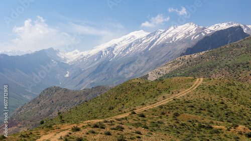 iran snowy mountains with a hills in the front with a dirt road