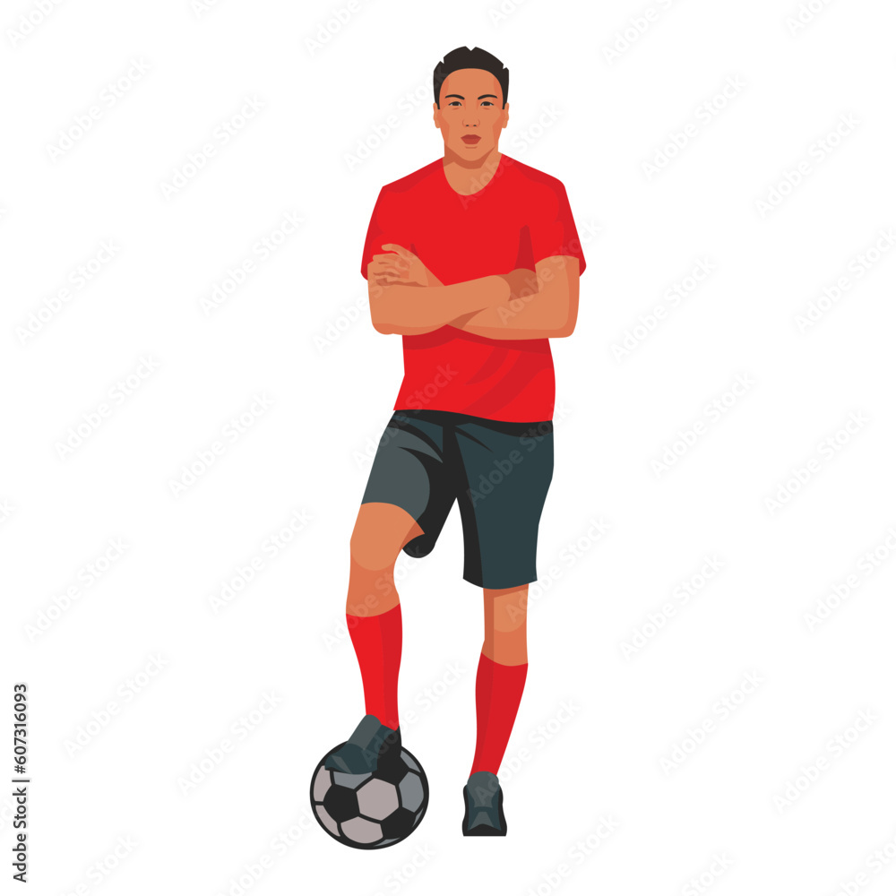 Professional asian football player in a red shirt stands with his foot on the ball and his arms folded on his chest