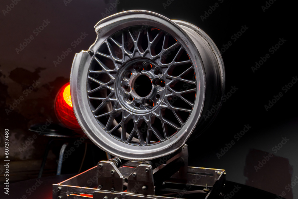 car wheels titanium rims after a traffic accident are gray in a dark room