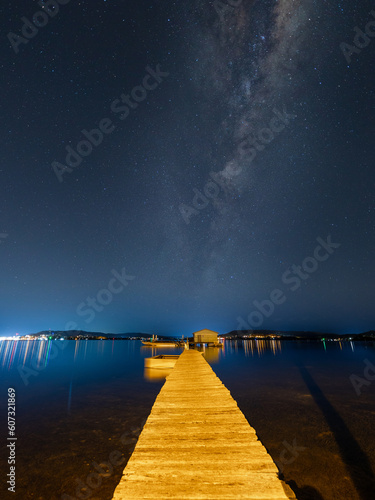 Milky way galaxy above the wooden hut in the lake.