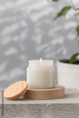 A burning white interior candle in a glass cup. The concept of home decor  comfort. Handmade candle