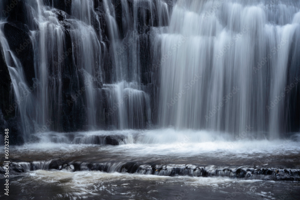 Scenic waterfall in slow motion up close in a New Zealand forest