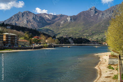 Buildings of the city of Lecco on the banks of the river Adda. Bridges and an island with mountains in the background