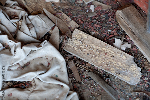 Old faded canvas material and broken pieces of timber piled on the floor photo