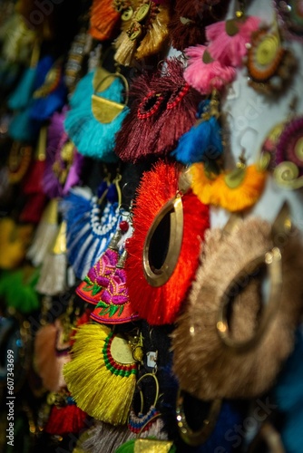 Vertical close-up of colorful handmade jewelry in the market on the wall