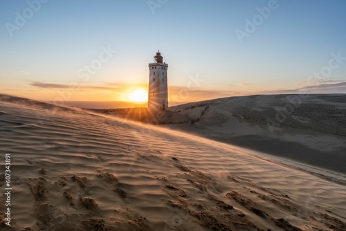 Beautiful view of Rubjerg Knude lighthouse in Lokken, Denmark with sunset scene