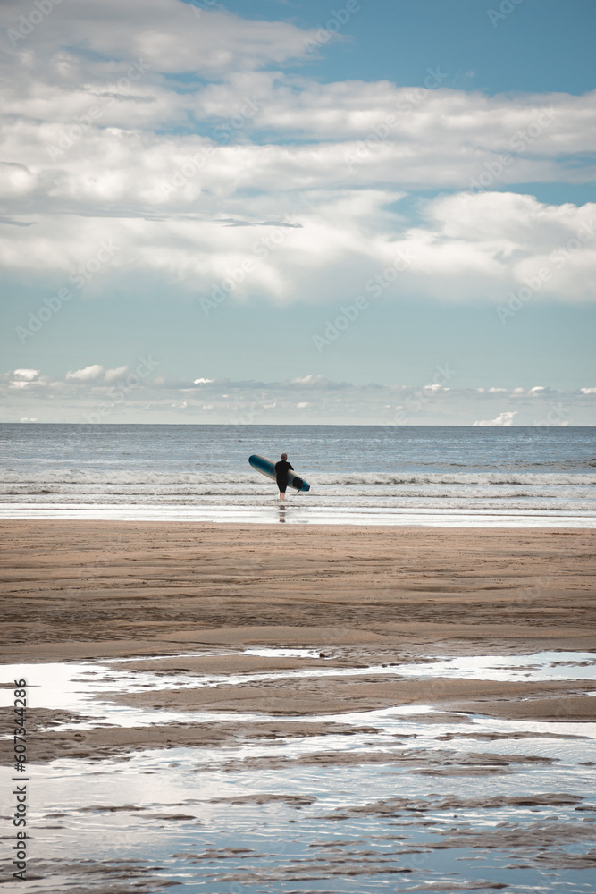 silueta de un surfista en la playa entrando en el mar