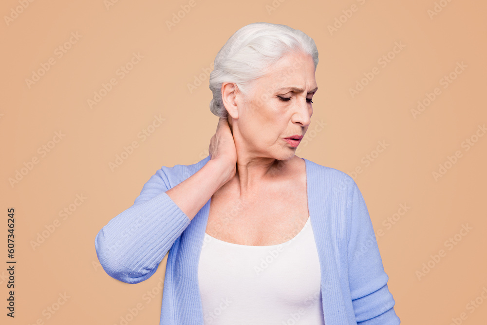 Gray haired old beautiful caucasian woman wearing casual suffering from neck pain, touching neck, closed eyes. Isolated over violet pastel background Gray haired old beautiful caucasian woman wearing casual suffering from neck pain, touching neck, closed eyes. Isolated over violet pastel background