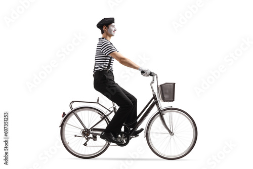 Full length profile shot of a mime riding a bicycle