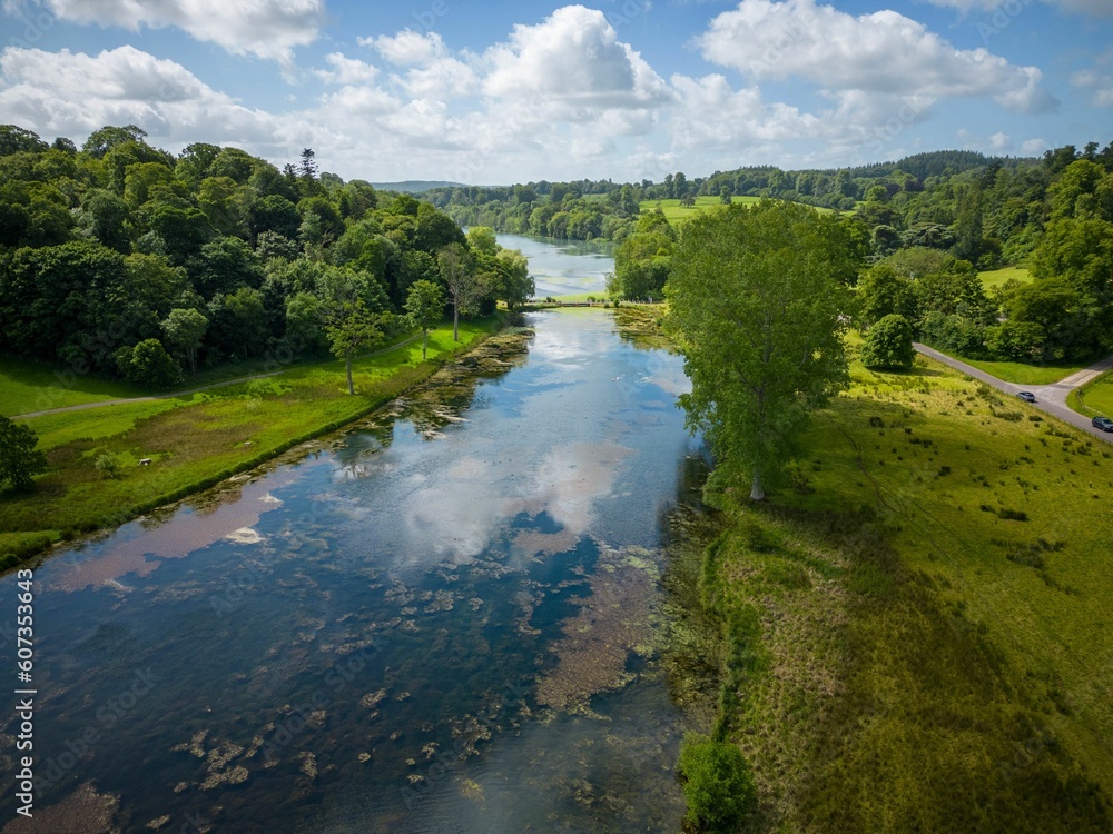Aerial drone shot of the green meadows and a river