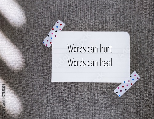 Obraz na plátně Paper note stick on wallpaper background with text Words can hurt Words can heal