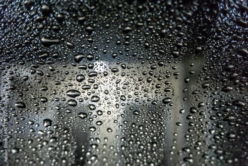 Closeup of a glass windows with rain droplets covering the surface