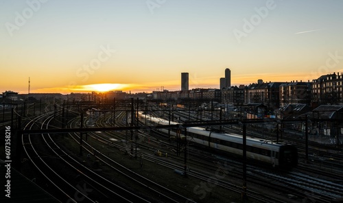 Beautiful scenery of a big train station surrounded by residential buildings during sunset © Jesper Jensen/Wirestock Creators