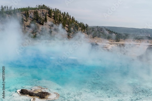 View of steam over the lake water before the hills landscape © Tyler Reinhardt/Wirestock Creators