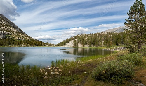 Panoramic shot of a Mammoth mountain lake with trees and mountains in the background © Steve Laret/Wirestock Creators