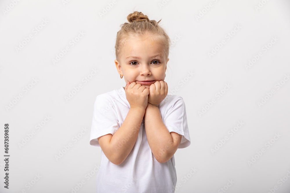 Smiling cute little blonde girl in white t-shirt isolated on white background. Copy space. Mock up Smiling cute little blonde girl in white t-shirt isolated on white background. Copy space. Mock up