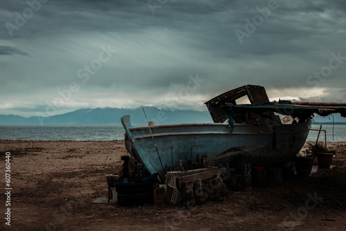 Fototapeta Naklejka Na Ścianę i Meble -  Αbandoned ship on the beach with snowy mountains moody winter