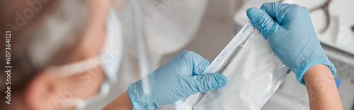 Картината върху платно Podiatrist opens pack with sterile metal probe to work with client feet nail in