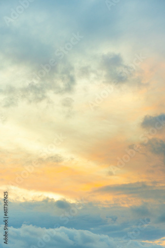 Fotografía vertical del cielo con nubes en la hora del atardecer, con texturas de colores.
