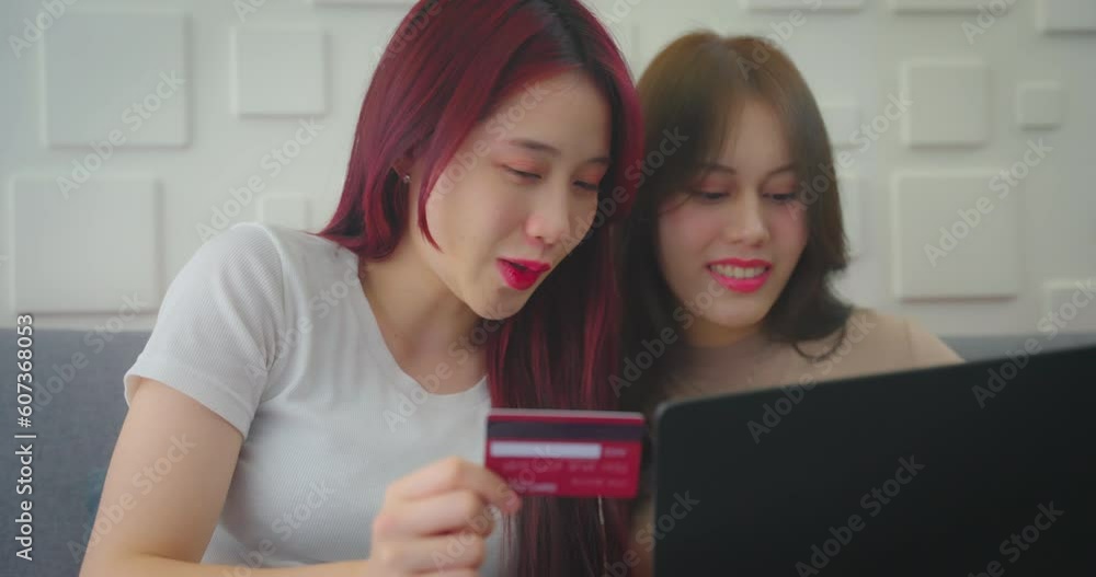 Young asian woman and friend using credit to shopping at home. She buying product in online store together at home. Young asian woman and friend using credit to shopping at home. She buying product in online store together at home.