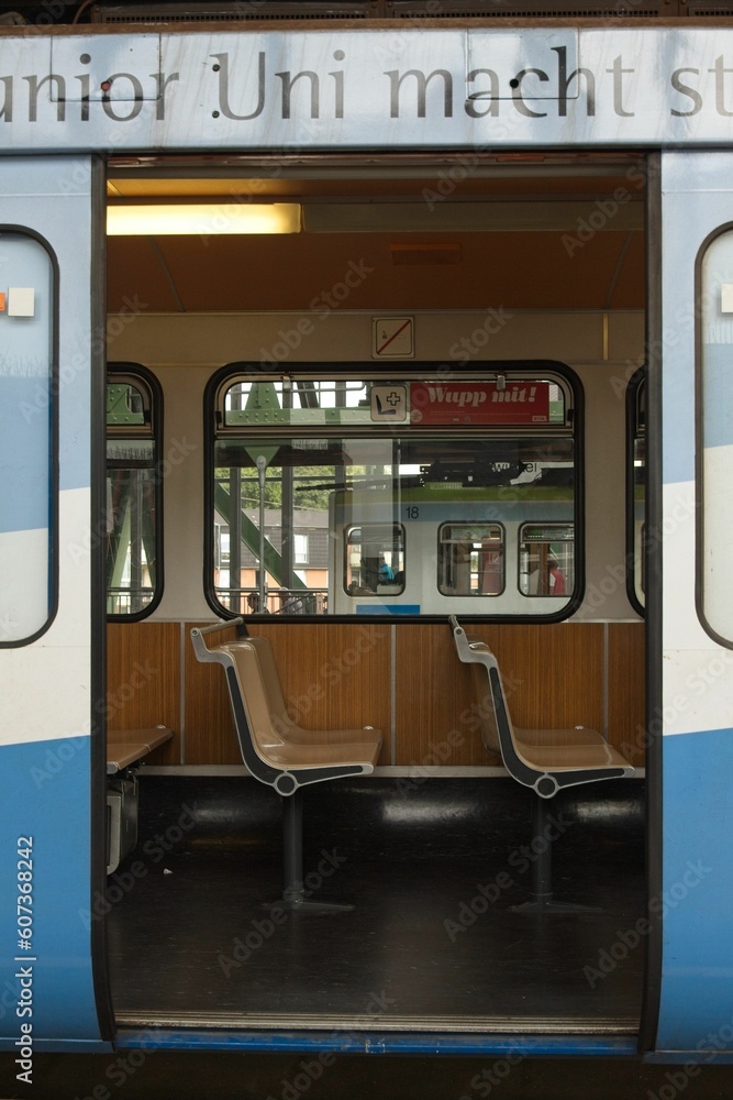 Vertical of the seats inside of the Wuppertal monorail captured through the open doors in Germany
