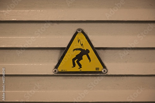 Closeup of the sign of a man getting hit with electricity, the cover of 