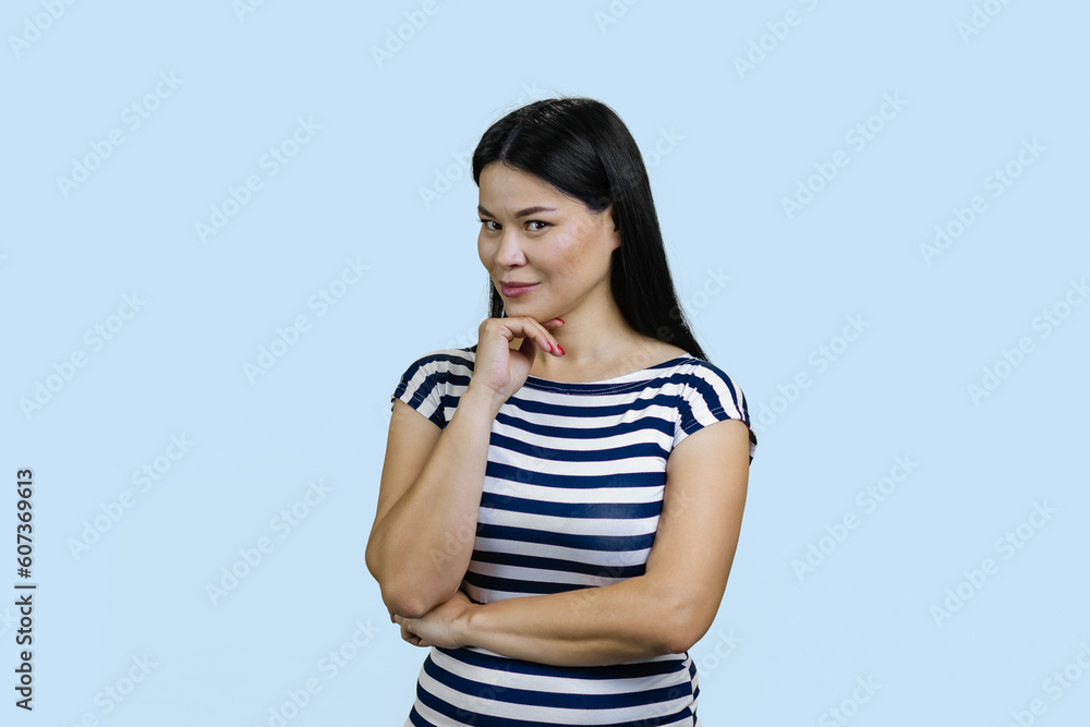 Portrait of a young brunette asian woman is looking at you seducively. Isolated on blue background. Portrait of a young brunette asian woman is looking at you seducively. Isolated on blue background.